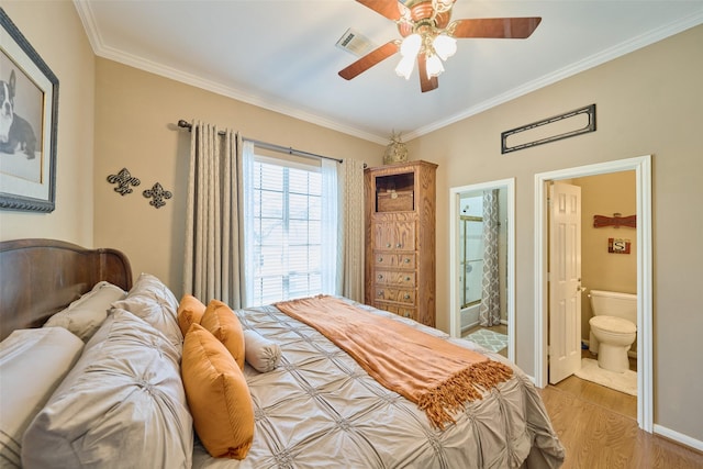 bedroom with light wood finished floors, visible vents, crown molding, ceiling fan, and ensuite bathroom