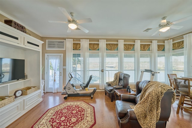 living area with a ceiling fan, wood finished floors, and visible vents