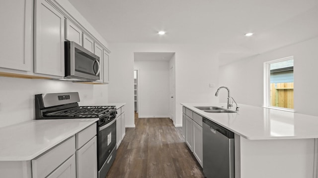 1658 Portia Ln, Conroe, TX 77301 - kitchen featuring stainless steel appliances, a sink, light countertops, a kitchen island with sink, and dark wood-style flooring