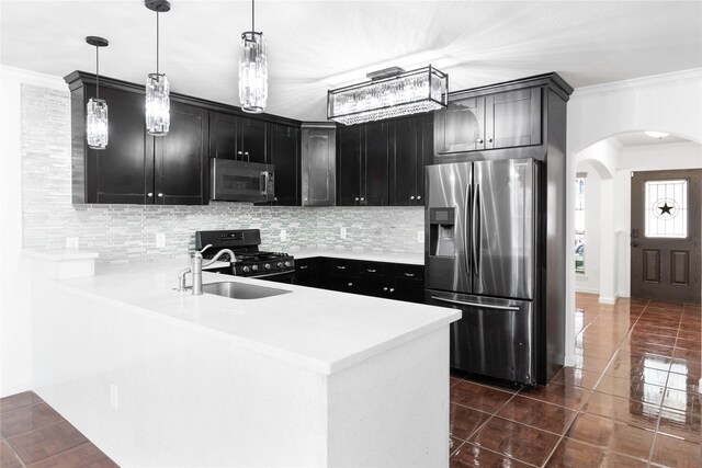 kitchen with appliances with stainless steel finishes, dark cabinetry, and decorative backsplash