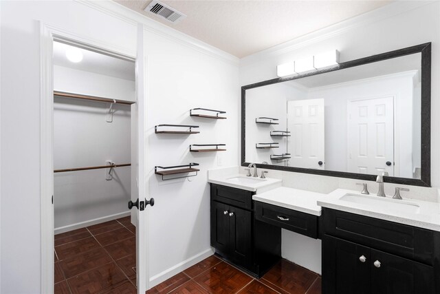 bathroom featuring baseboards, visible vents, ornamental molding, a spacious closet, and vanity