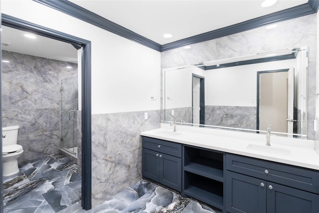 bathroom with tile walls, toilet, marble finish floor, crown molding, and a sink