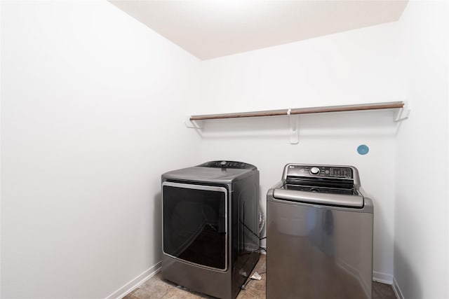 laundry area with laundry area, washer and clothes dryer, and baseboards