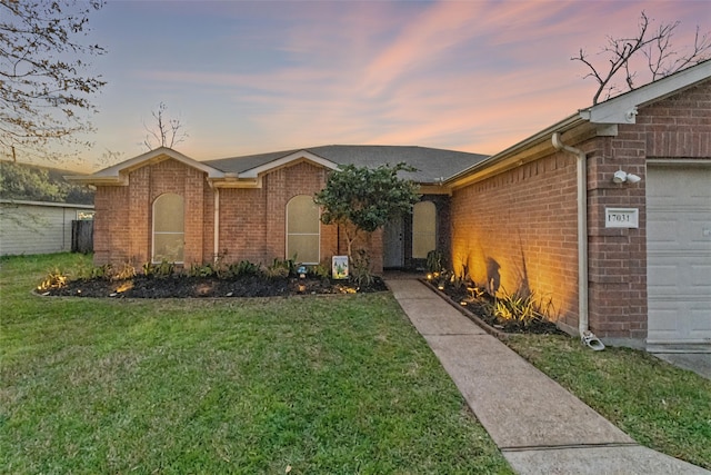 ranch-style home with a front lawn, a garage, and brick siding