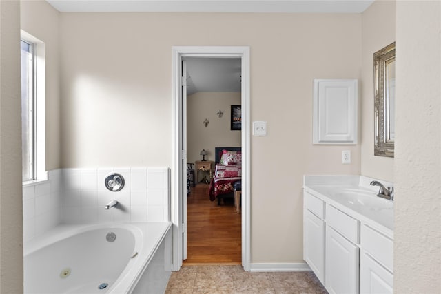 full bath featuring tile patterned floors, a tub with jets, ensuite bath, and vanity