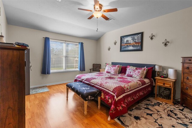 bedroom featuring baseboards, a ceiling fan, lofted ceiling, and wood finished floors