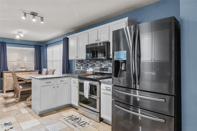 kitchen with decorative backsplash, stone counters, a peninsula, white cabinets, and stainless steel appliances