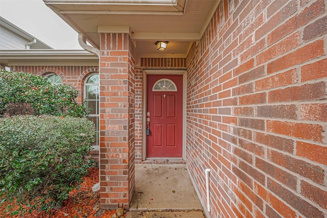 view of exterior entry featuring brick siding