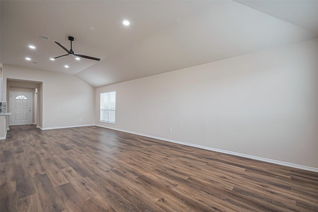 empty room featuring baseboards, visible vents, dark wood finished floors, lofted ceiling, and recessed lighting