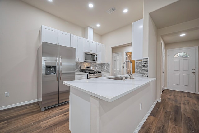 kitchen with visible vents, decorative backsplash, stainless steel appliances, white cabinetry, and a sink