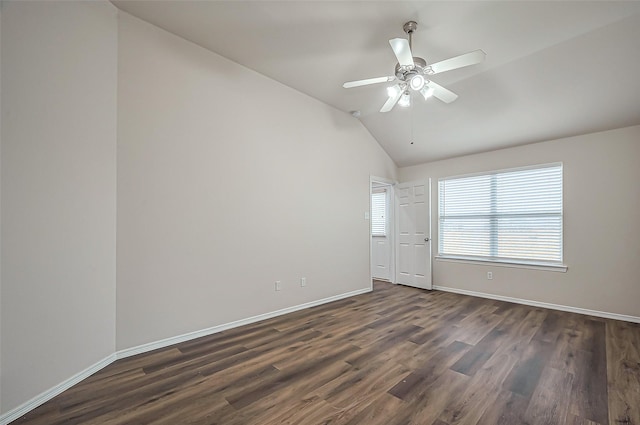 empty room with lofted ceiling, ceiling fan, baseboards, and dark wood-style flooring