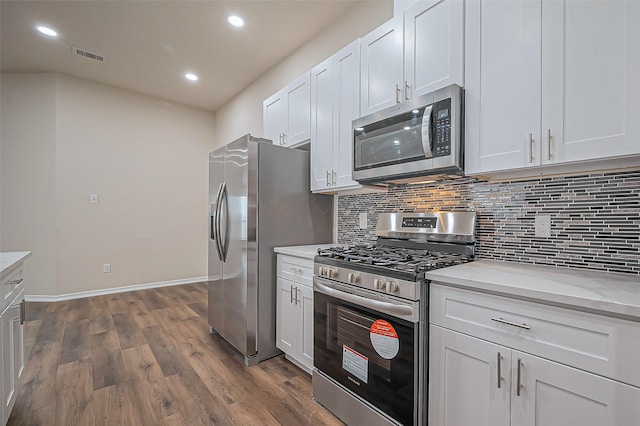 kitchen with stainless steel appliances, dark wood-style flooring, visible vents, light countertops, and backsplash