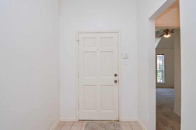 foyer entrance featuring light tile patterned floors, a ceiling fan, and baseboards