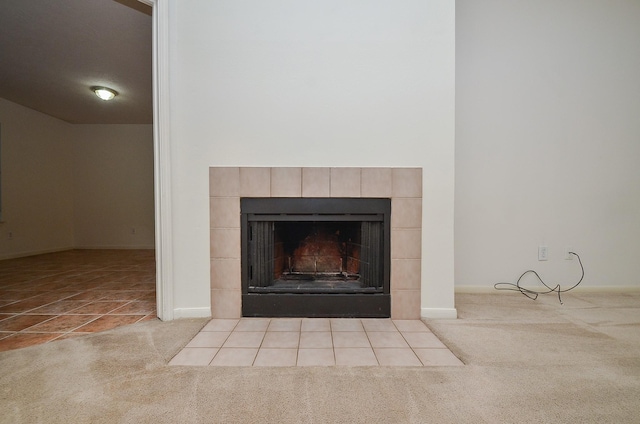 interior details with carpet and a tiled fireplace