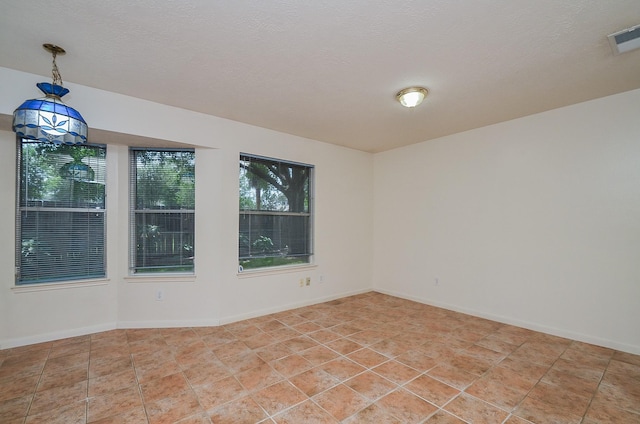 unfurnished room featuring visible vents, a textured ceiling, baseboards, and light tile patterned floors