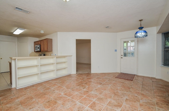 foyer entrance featuring light tile patterned floors, visible vents, and a textured ceiling