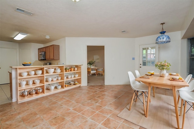 dining room with visible vents, a textured ceiling, and light tile patterned flooring