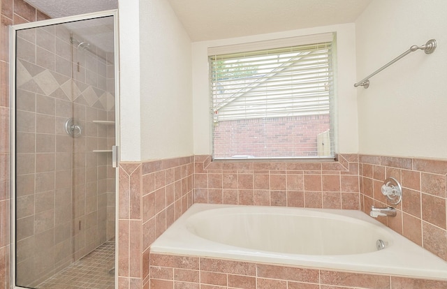 bathroom featuring a garden tub and a shower stall