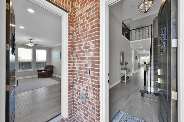 entrance foyer featuring baseboards, crown molding, and wood finish floors