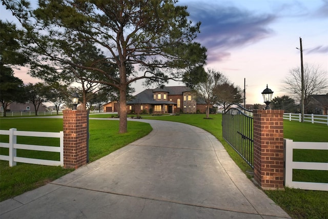 view of front of property with a gate, driveway, a front yard, and fence