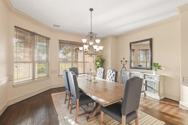 dining room featuring visible vents, baseboards, hardwood / wood-style floors, and crown molding