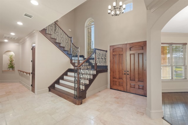 entrance foyer featuring crown molding, baseboards, and visible vents