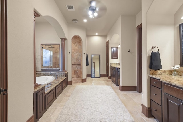 bathroom featuring vanity, baseboards, visible vents, walk in shower, and a bath