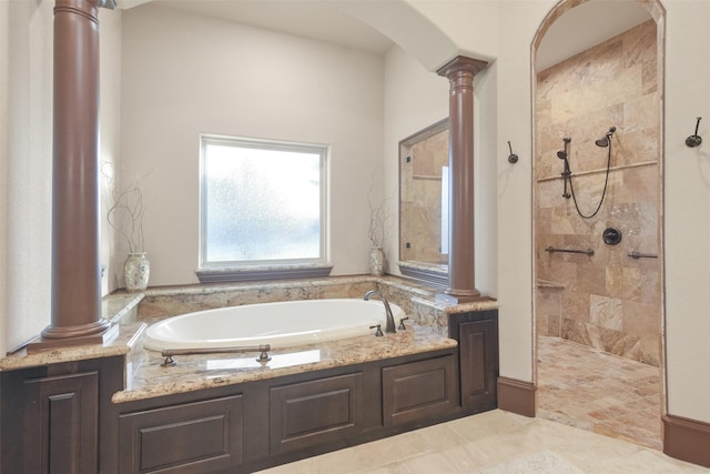 bathroom featuring a tile shower, a garden tub, and ornate columns