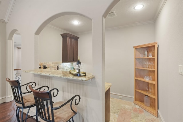 bar featuring tasteful backsplash, visible vents, crown molding, and baseboards