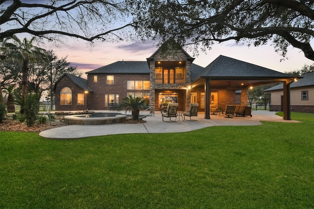 rear view of house with an outdoor living space, a lawn, ceiling fan, and a patio area