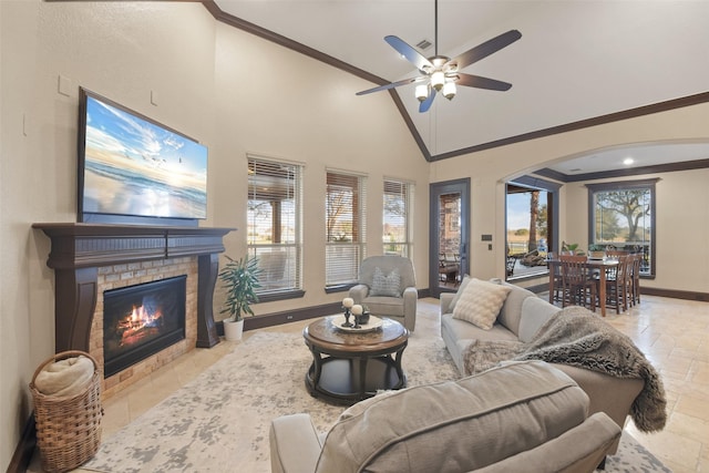 living room with crown molding, baseboards, arched walkways, and high vaulted ceiling