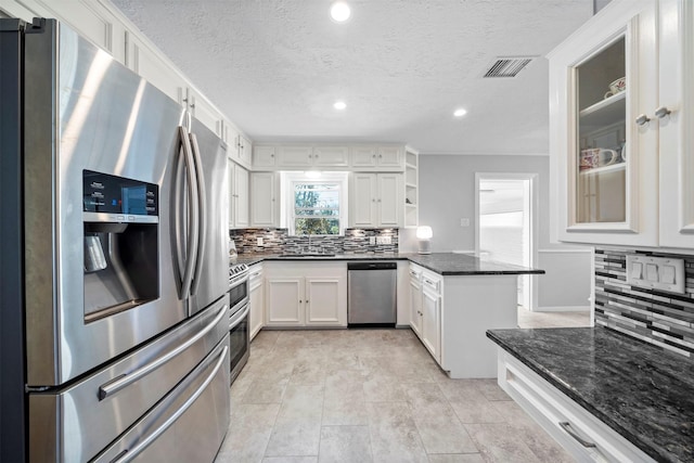 kitchen featuring visible vents, a peninsula, open shelves, stainless steel appliances, and decorative backsplash