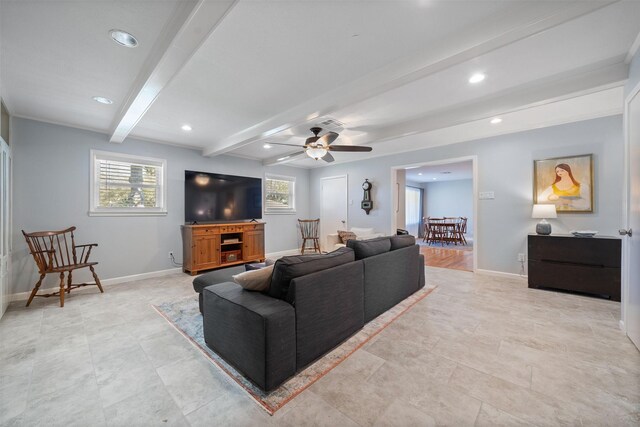 living area featuring baseboards, beam ceiling, and a healthy amount of sunlight