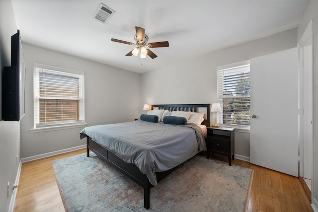 bedroom with visible vents, baseboards, light wood-style flooring, and a ceiling fan