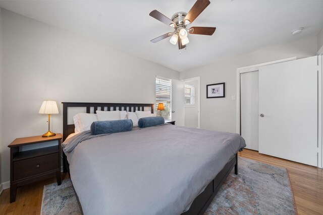 bedroom with a closet, wood finished floors, and a ceiling fan