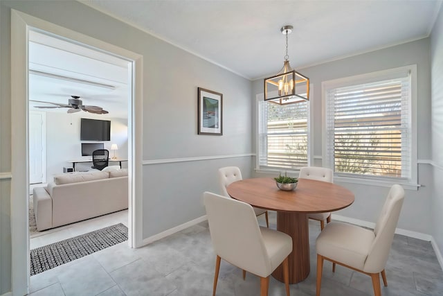 dining room with crown molding, light tile patterned flooring, ceiling fan with notable chandelier, and baseboards