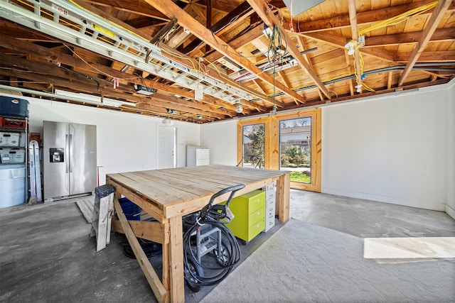 garage featuring washer and dryer and stainless steel refrigerator with ice dispenser