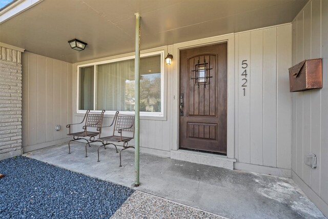 doorway to property with brick siding and covered porch