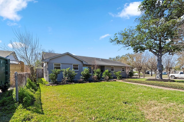 ranch-style home with a front lawn and fence