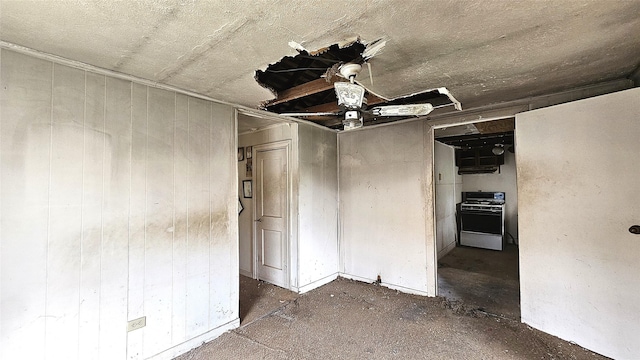 spare room with ceiling fan and wooden walls