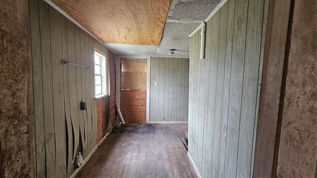 empty room with hardwood / wood-style flooring and wooden walls