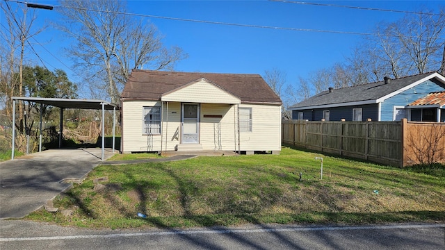 view of front of property with entry steps, driveway, a front lawn, and fence