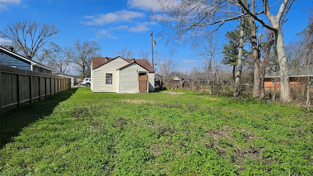 view of yard featuring a fenced backyard and an outbuilding