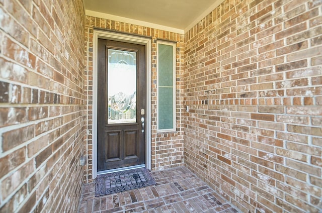 doorway to property featuring brick siding