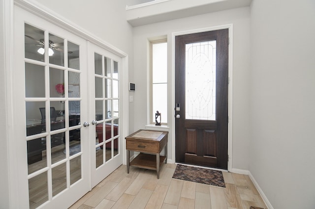 foyer with french doors, wood finish floors, a ceiling fan, and baseboards