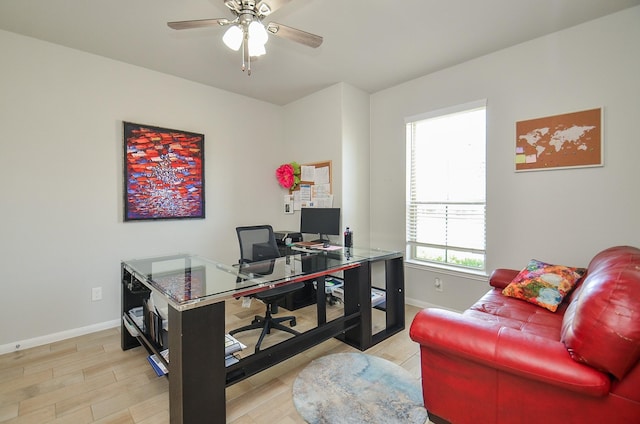 home office featuring light wood finished floors, ceiling fan, and baseboards