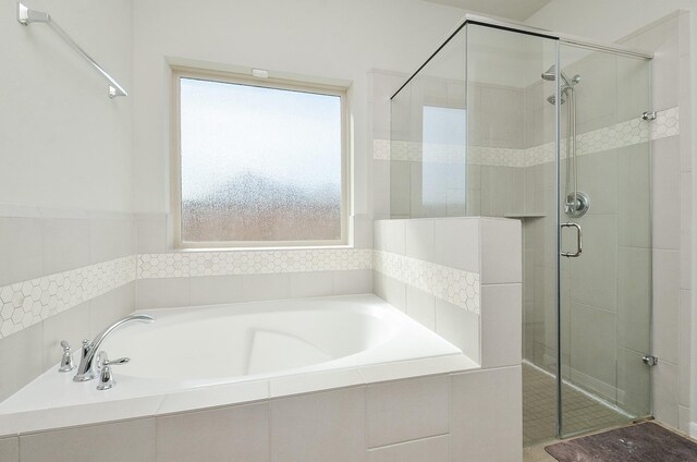 bathroom with a shower stall and a bath