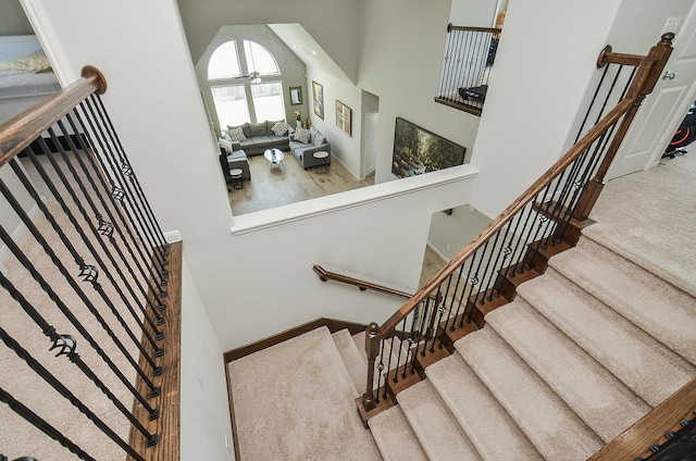 stairs with carpet floors and a high ceiling