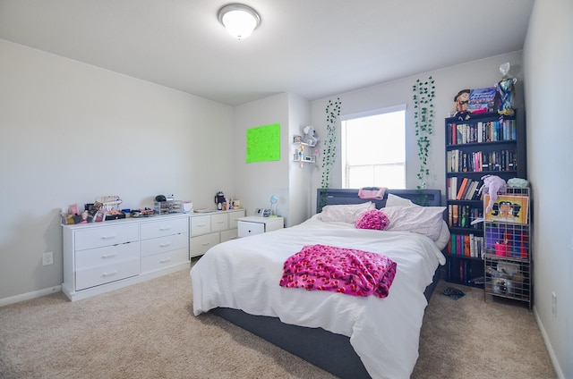 bedroom featuring light carpet and baseboards