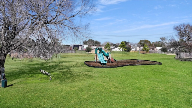 view of yard featuring playground community and fence